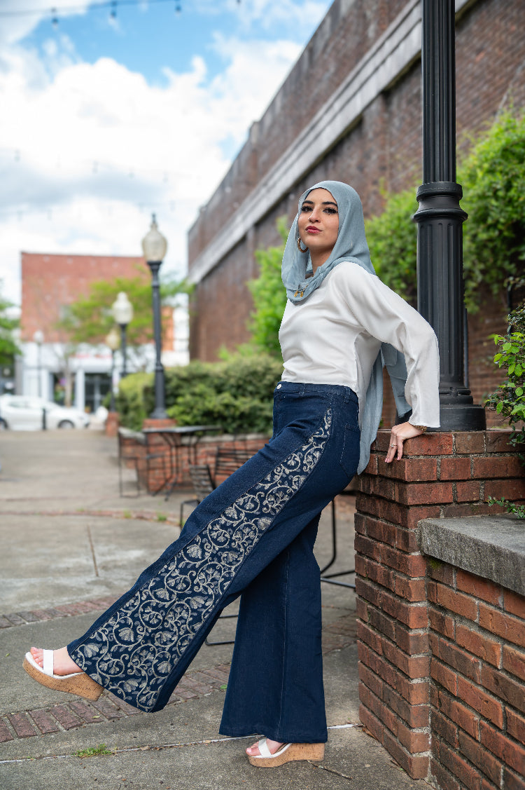 Woman wearing DuoCut embroidered wide-leg jeans with panels revealed for an elevated dinner or event outfit.