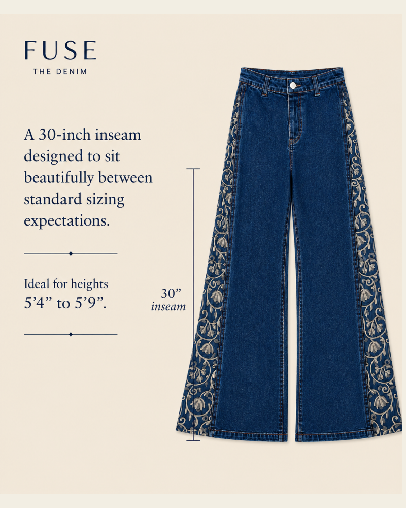 Blue wide-leg denim jeans with ornate beige floral embroidery down the outer sides, shown on a light beige background with text describing a 30-inch inseam and fit for heights 5'4" to 5'9". The brand FUSE THE DENIM is visible at the top left.