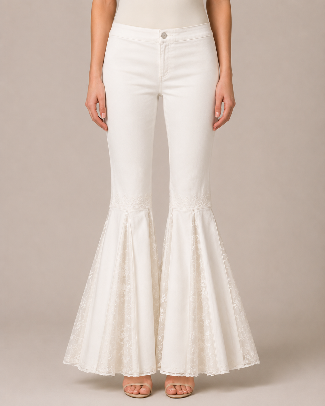 White flared pants with lace detailing at the lower hems, shown on a model against a neutral beige background.