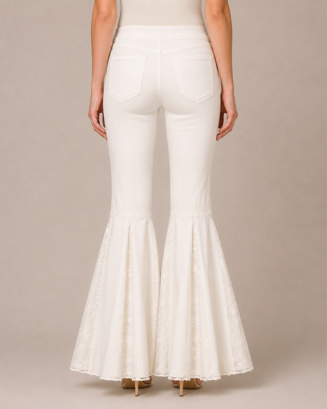 White flared pants with lace detailing at the hem, shown from the back on a model against a neutral beige background.
