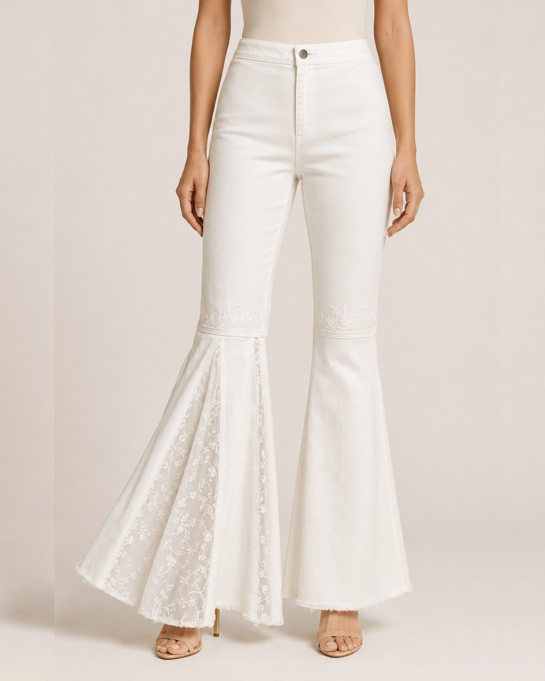 Blue wide-leg denim pants with beige floral embroidery running down the outer sides, shown flat against a white background.