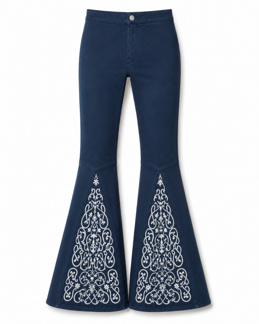 A pair of dark blue denim flare jeans with intricate white embroidered patterns on the lower flares, shown against a plain white background.